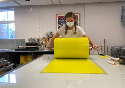 Apprentice Printer rolling out yellow during the proofing process with Ellen Berkenblit