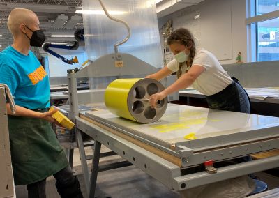 Apprentice Printer rolling out yellow during the proofing process with Ellen Berkenblit