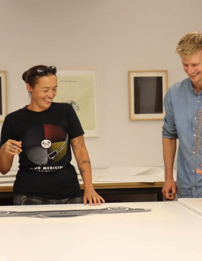 Rose Simpson signing her lithograph, Maria, with Tamarind Curator Ben Schoenburg