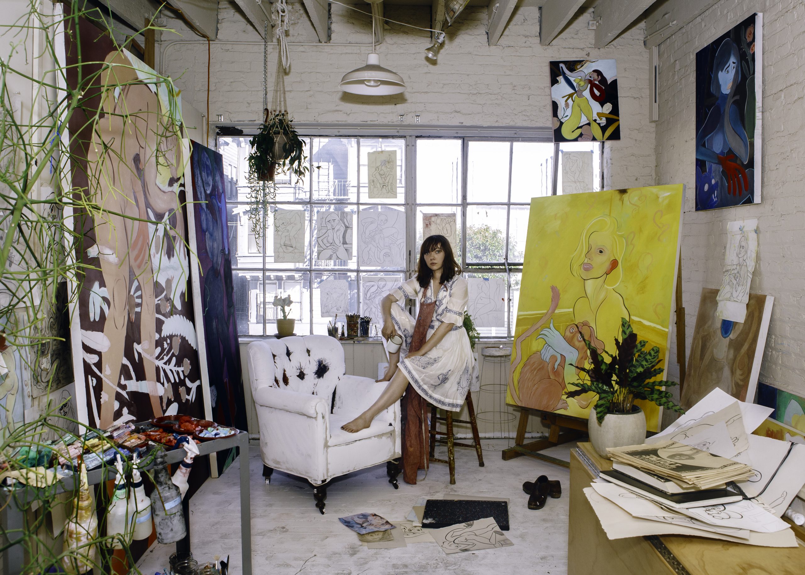 Koak in her studio with her paintings